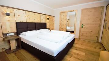 Ein modernes Schlafzimmer mit einem großen Bett, Holzwandverkleidung, einem Einbauschrank und einem Spiegel.