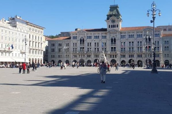 A large public square with historic buildings, including a prominent clock tower.