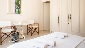 Une chambre à coucher avec un lit, une fenêtre, une table, des chaises et une armoire.