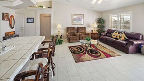 A spacious living room with a dining area, a brown leather sofa, and a patterned rug. - Havasu Hacienda Private Pool! (Lake Havasu City)