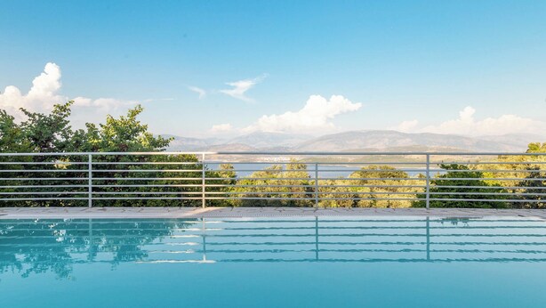 A swimming pool with a view of mountains and a clear sky.