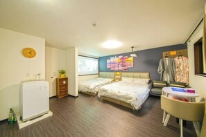 Hotelkamer met twee bedden, een tafeltje, een stoel, een verwarming, een klok en een raam.