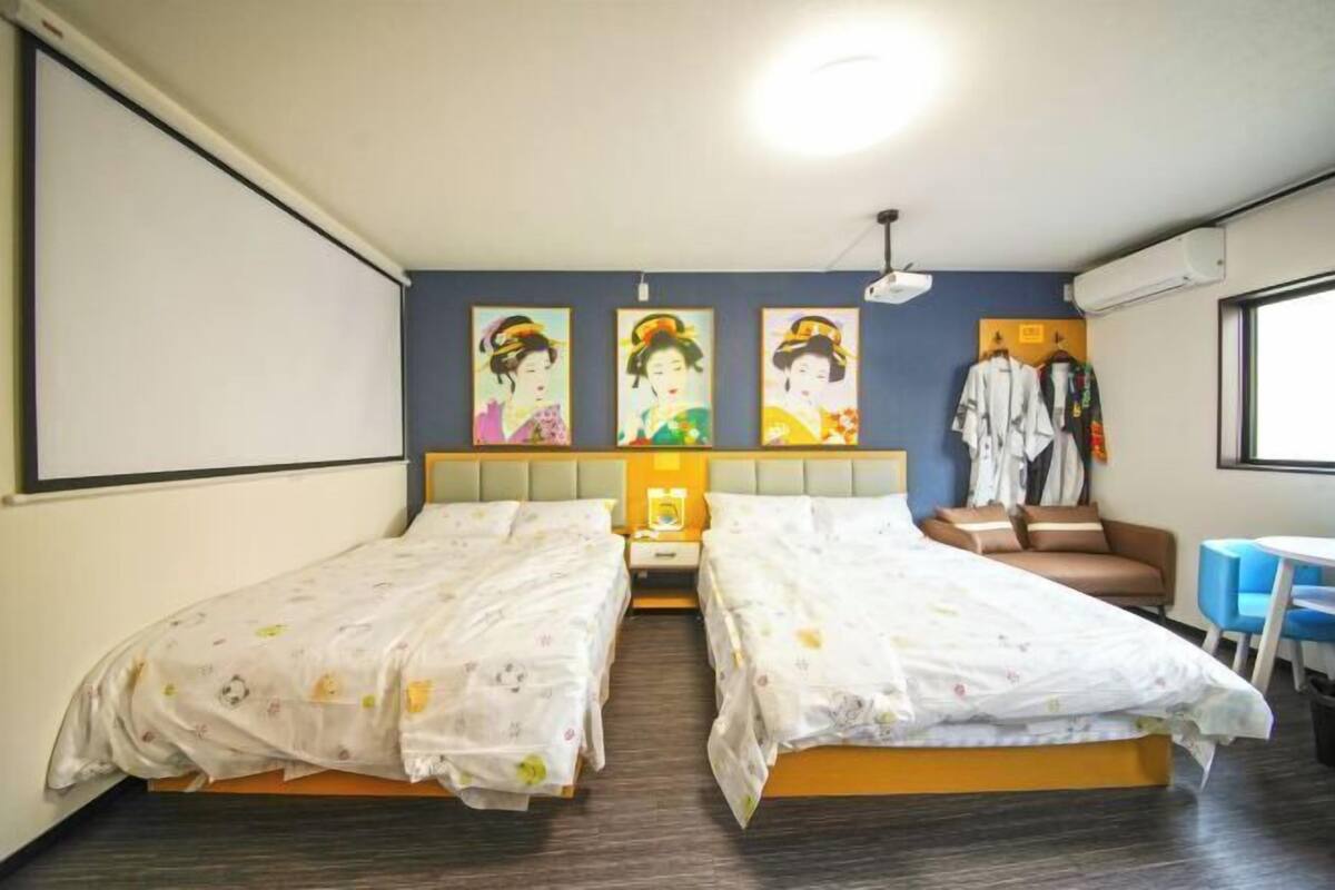 Une chambre d’hôtel avec deux lits, un bureau, une chaise, une armoire et des  œuvres d’art murales.