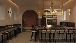 Eine moderne Bar mit einer Marmorplatte, mehreren Barhocker und einem Weinkühlschrank.