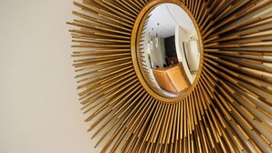 A sunburst mirror with a wooden frame. - Hotel Lutz (Rain)