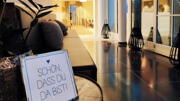 A modern lobby with a reception desk, seating area, and large windows. - Hotel Lutz (Rain)
