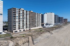 A multi-story hotel with balconies, a beach view, and a sandy beach area. - Extraordinary 3BR Oceanfront Escape | 2 Balconies (Ocean City)
