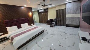 A modern bedroom with a large bed, a desk, and a wardrobe. - SC Hotel (Papumpare)
