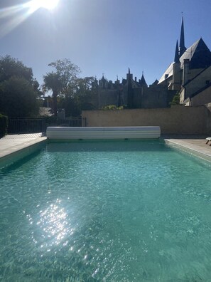 A clear swimming pool with a castle-like structure in the background.