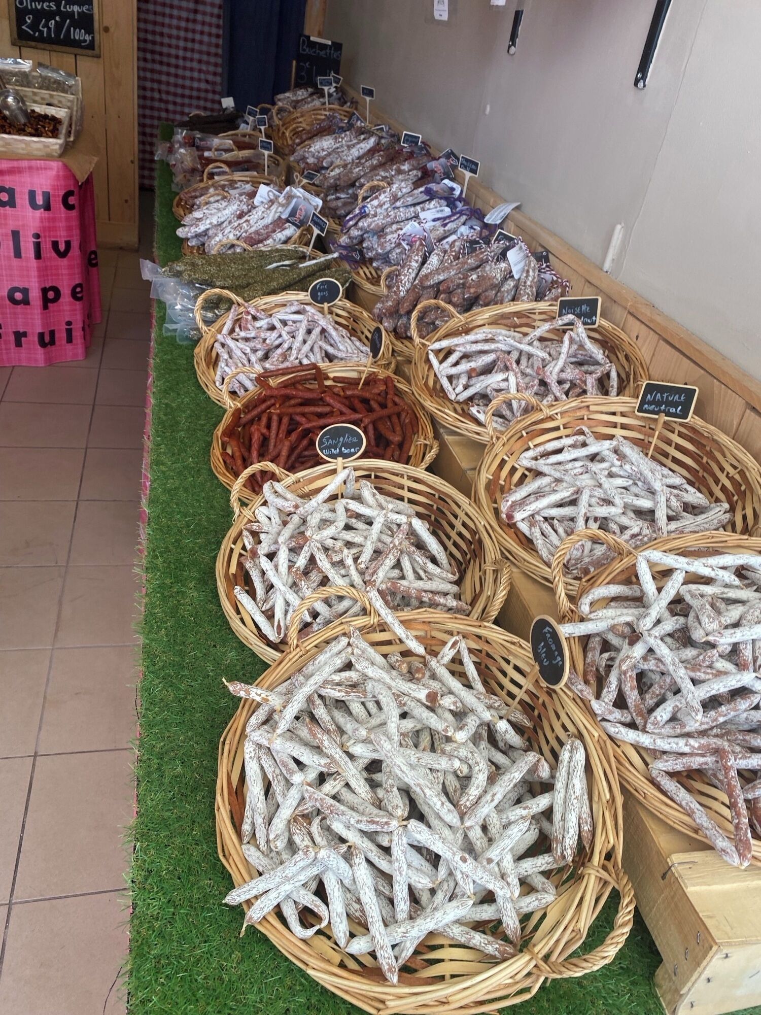 Une variété de poissons séchés est exposée dans des paniers en osier sur un étal de marché.
