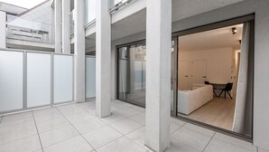 A modern interior with a glass door leading to a dining area and a living room. - Newly Built Studio on 1st Floor With Terrace (Middelkerke)