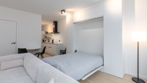A modern, minimalist bedroom with a bed, a desk, and a chair. - Newly Built Studio on 1st Floor With Terrace (Middelkerke)