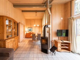 Un intérieur en bois avec une cheminée, un téléviseur et un coin repas.