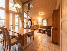 Un intérieur chaleureux en bois, comprenant un coin repas, un canapé et une cuisine.