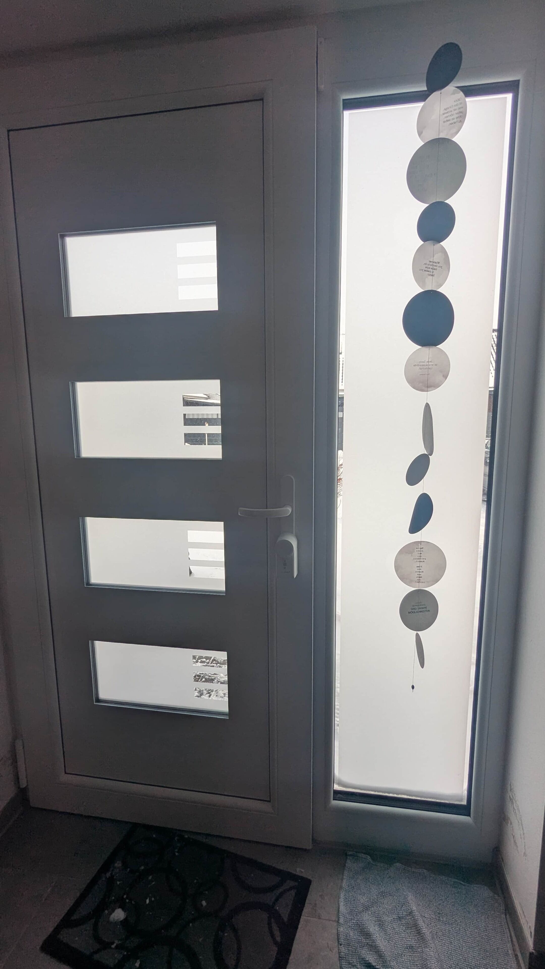 A door with frosted glass panels and a vertical string of circular decorations.
