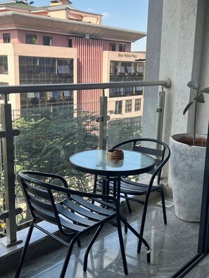Enjoy the view from this balcony overlooking Blue Vole's Plaza, featuring a tree and neighboring building.