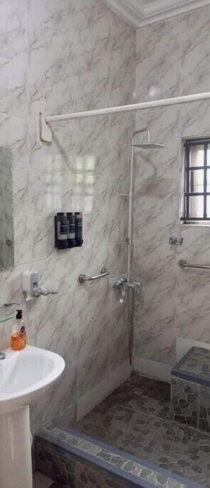 Een douche, handdoeken, zeep, toiletpapier