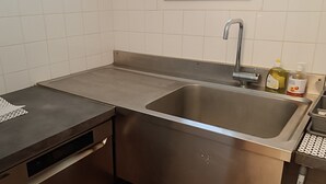 A stainless steel kitchen with a sink, a dish drying mat, and a soap dispenser. - Gite d'étape Benjamin sur le sentier Cathare (3-person room) (Prugnanes)