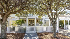 A white wooden house with a covered porch, surrounded by trees and a wooden fence. - Beachside in Seaside, FL, 3 King Suites, Amazing Gulf Views - 2 Adult Bikes! (Santa Rosa Beach)