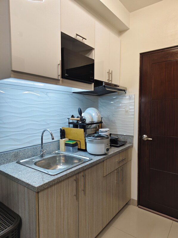 Una cocina moderna con encimera de granito, pileta de acero inoxidable y armarios de madera.