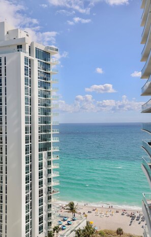 A high-rise hotel with a view of a beach and ocean.