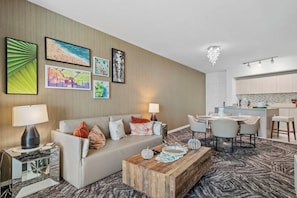 Een hotelkamer met een bank, salontafel en kunstwerk aan de muur.