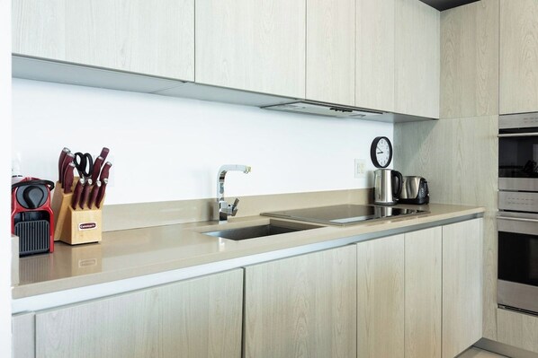 A modern kitchen with a sink, stainless steel appliances, and wooden cabinetry.