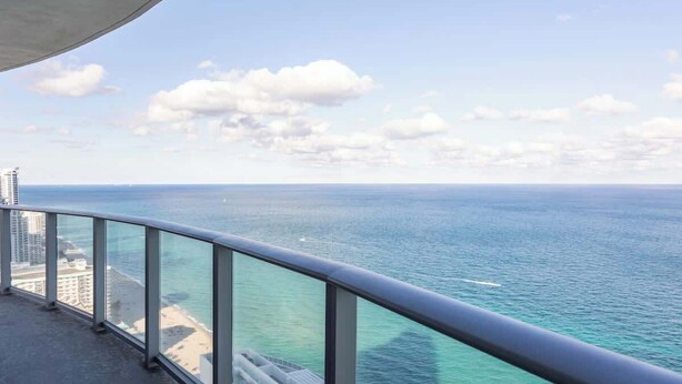 En balkon med udsigt over havet og stranden.