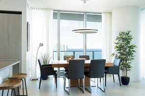 Un espace repas moderne avec une table en bois, des chaises noires et une plante en pot.