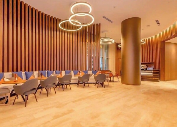 Een modern interieur met een zithoek, houten lambrisering en een receptiebalie.