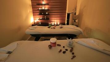 Experience ultimate relaxation in this serene spa room, featuring two massage tables and a tranquil atmosphere.