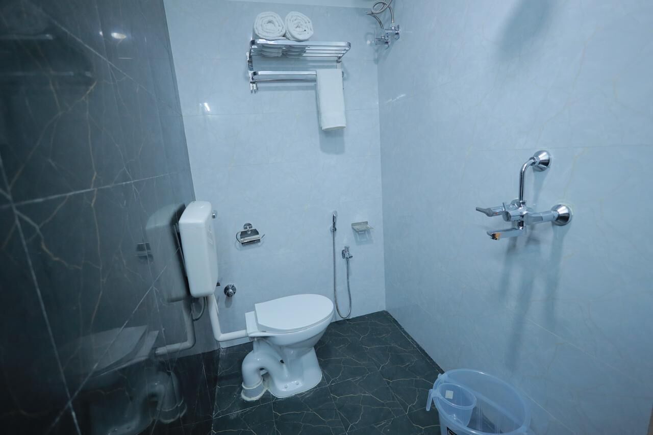 Un baño pequeño con inodoro, ducha y toallero.