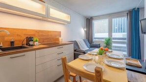 Una cocina compacta con comedor, armarios de madera y horno empotrado.
