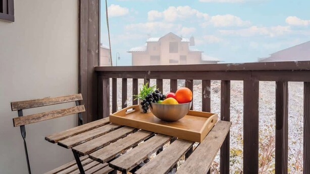 A wooden bench with a tray holding a bowl of fruit and a small plant.