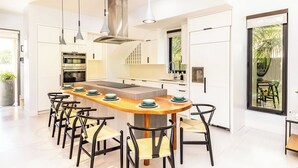 A modern kitchen with a central island, pendant lighting, and a view of the outdoors. - Lotus Villas #1-Leeward Palms. Your Gateway to Paradise & Step into Serenity.... (Leeward Settlement)