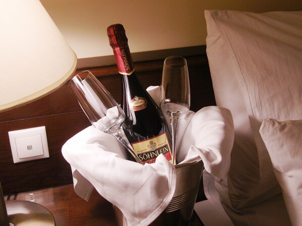 Un minibar con una botella de champán SÖHNLEIN y dos copas.