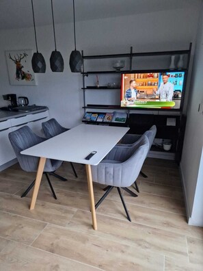 Enjoy cooking and dining in this well-equipped kitchen with stove, coffee machine, and sink, and a dining area with a table and two chairs.