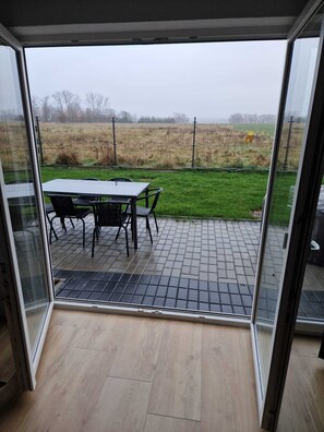 Relax in this open-plan living space with a patio area leading to a fenced outdoor space.