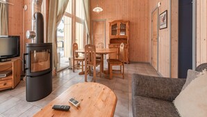 Un interior acogedor de madera con chimenea, comedor y sofá.