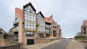 A modern multi-story residential building with balconies, large windows, and a brick facade. - Apartment in De Panne Near the Beach (Koksijde)