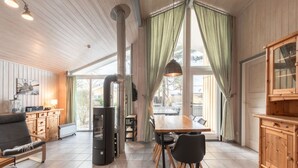 A cozy cabin interior with a dining area, kitchen, and seating space. - Ferienhaus mit Sauna im Ferienpark Mirow (Mirow)