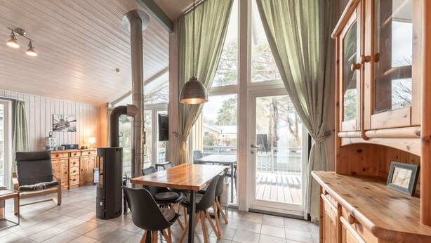 A spacious kitchen with wooden cabinets, a dining table, and chairs. - Ferienhaus mit Sauna im Ferienpark Mirow (Mirow)