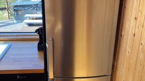 A stainless steel refrigerator in a kitchen with a wooden countertop and a view of a lake and mountains. - Tranquil 4-bedrooms in two cottages Near Golden Circle-10 sleeps with WiFi, AC (Grímsnes- og Grafningshreppur)