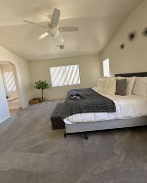 A bedroom with a bed, a ceiling fan, a window, and a plant. - Spacious Stargazing Sleeps 10 Secret Gem 4BD3BA HotTub, Treadmill, Keyless Entry (Tucson)
