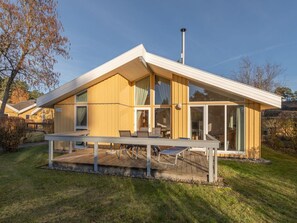 Uma casa moderna com um terraço amplo, uma chaminé e o número '197' na lateral.
