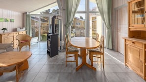 Una habitación amplia con una gran mesa de comedor, sillas, un sofá, una chimenea y una zona de cocina con armarios de madera.