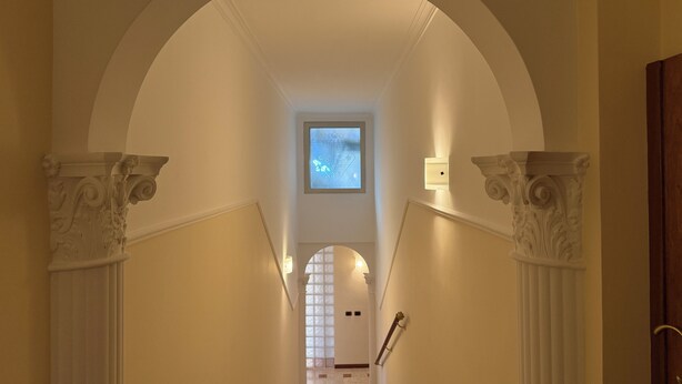 A grand hallway with an arched ceiling, white walls, and classical columns. - Apartment in the heart of EUR (Roma)