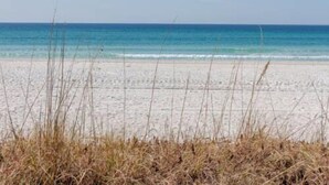 Ein Strand mit klarem, blauem Wasser und weißem Sand.