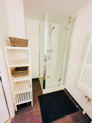 Een douche, een haardroger, handdoeken, toiletpapier