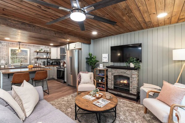 A modern kitchen with a built-in oven, a refrigerator, and a dining area with a wooden table and chairs.